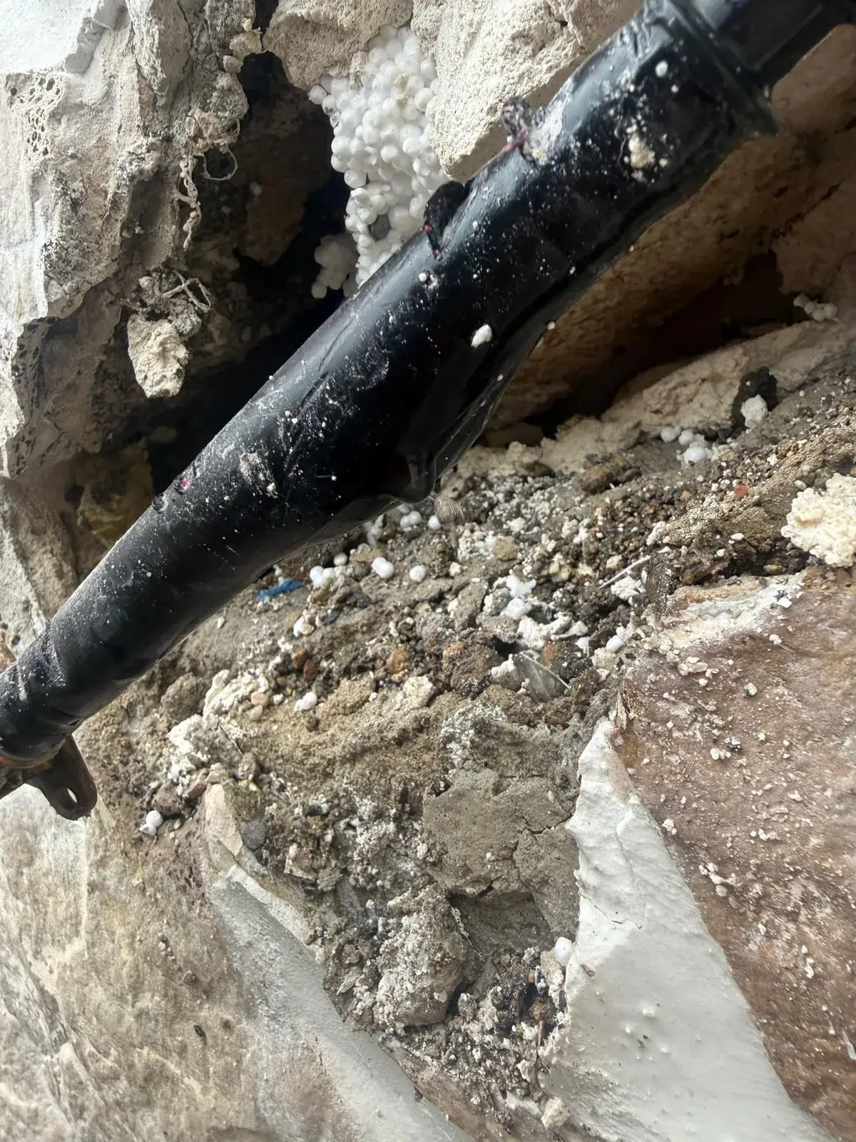 Geöffnete Wand mit freigelegter Leitung als Ergebnis einer Leckortung